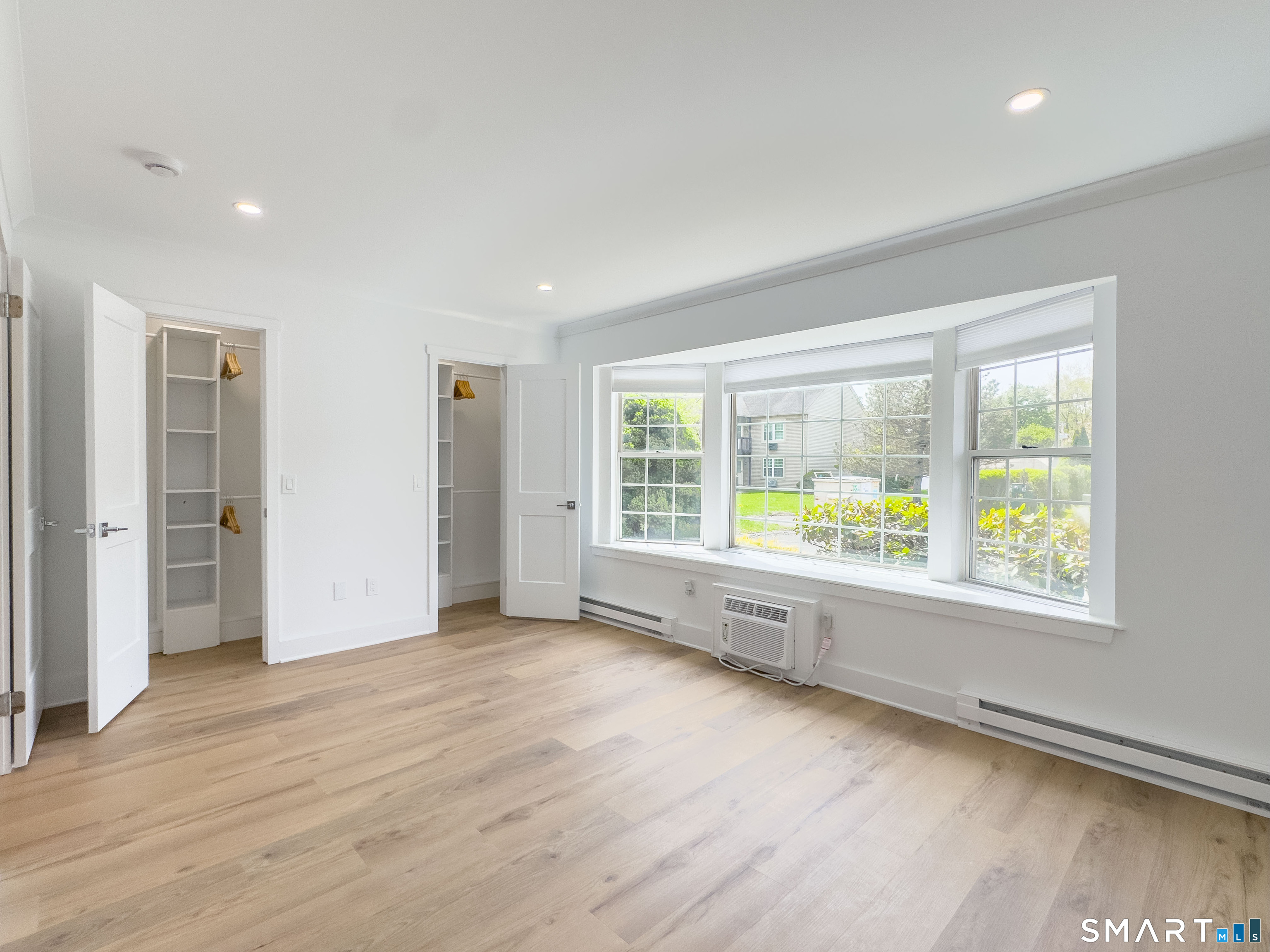 63 Glen Ridge Court, Unit 63 New Milford, CT 06776 - Photo 10 of 15 an empty room with wooden floor and windows