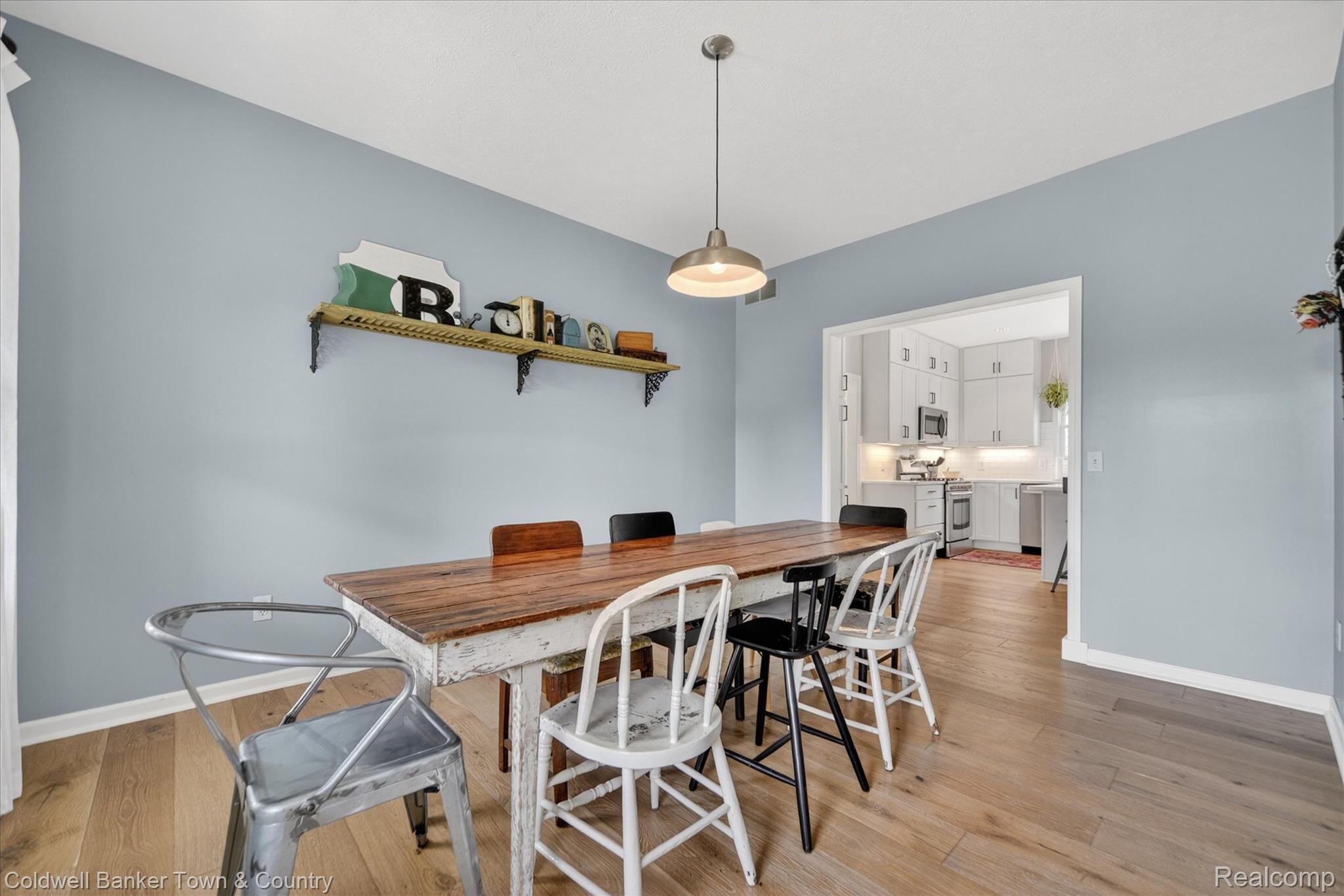 918 Gray Fox Court Howell, MI 48843 - Photo 18 of 84 Dining area featuring wood-finish flooring, a contemporary pendant light fixture, and a built-in wall shelf