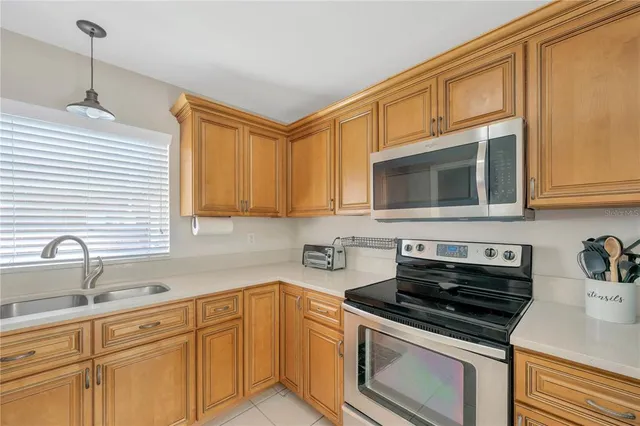a kitchen with stainless steel appliances granite countertop a sink stove and microwave