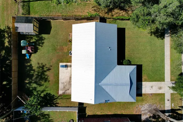 an aerial view of a house with swimming pool and garden