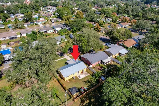 an aerial view of residential houses with outdoor space and trees