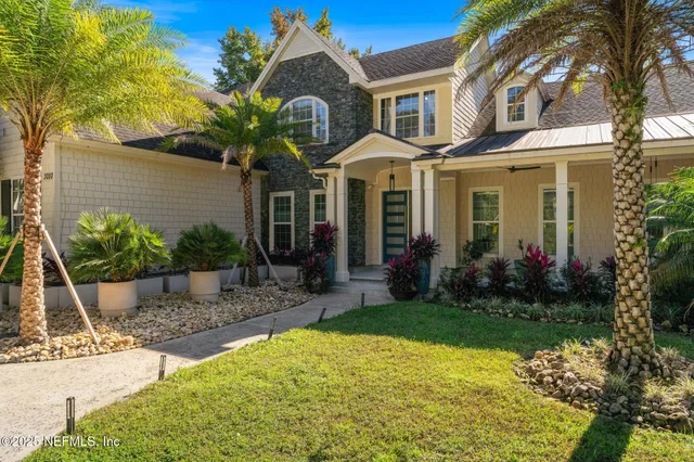 an aerial view of a house with a yard and lake view