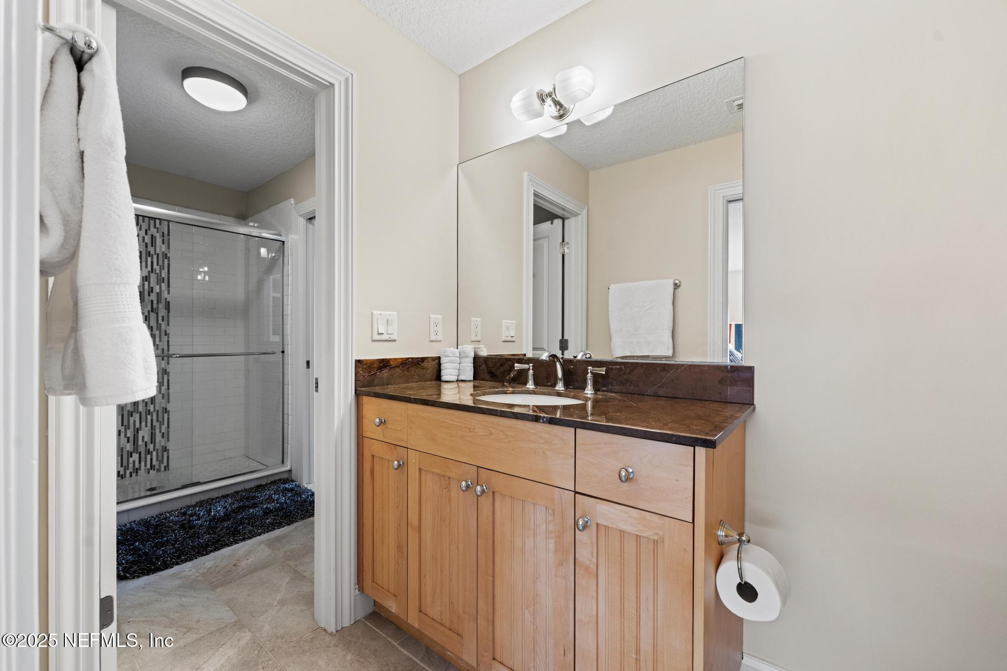 3010 Starratt Road Jacksonville, FL 32226 - Photo 66 of 106 a bathroom with a granite countertop sink a mirror and a shower