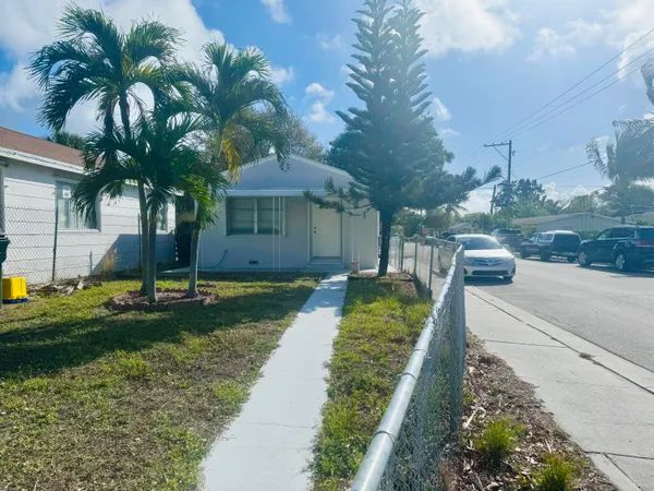 a view of a house with a yard and potted plants