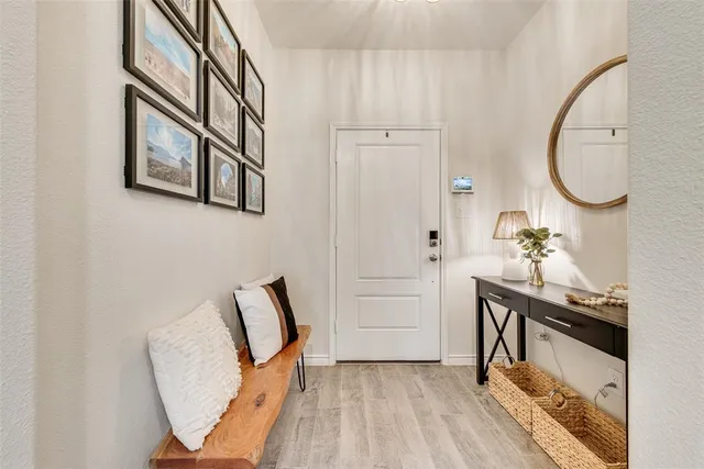 a view of a hallway with entryway wooden floor and front door