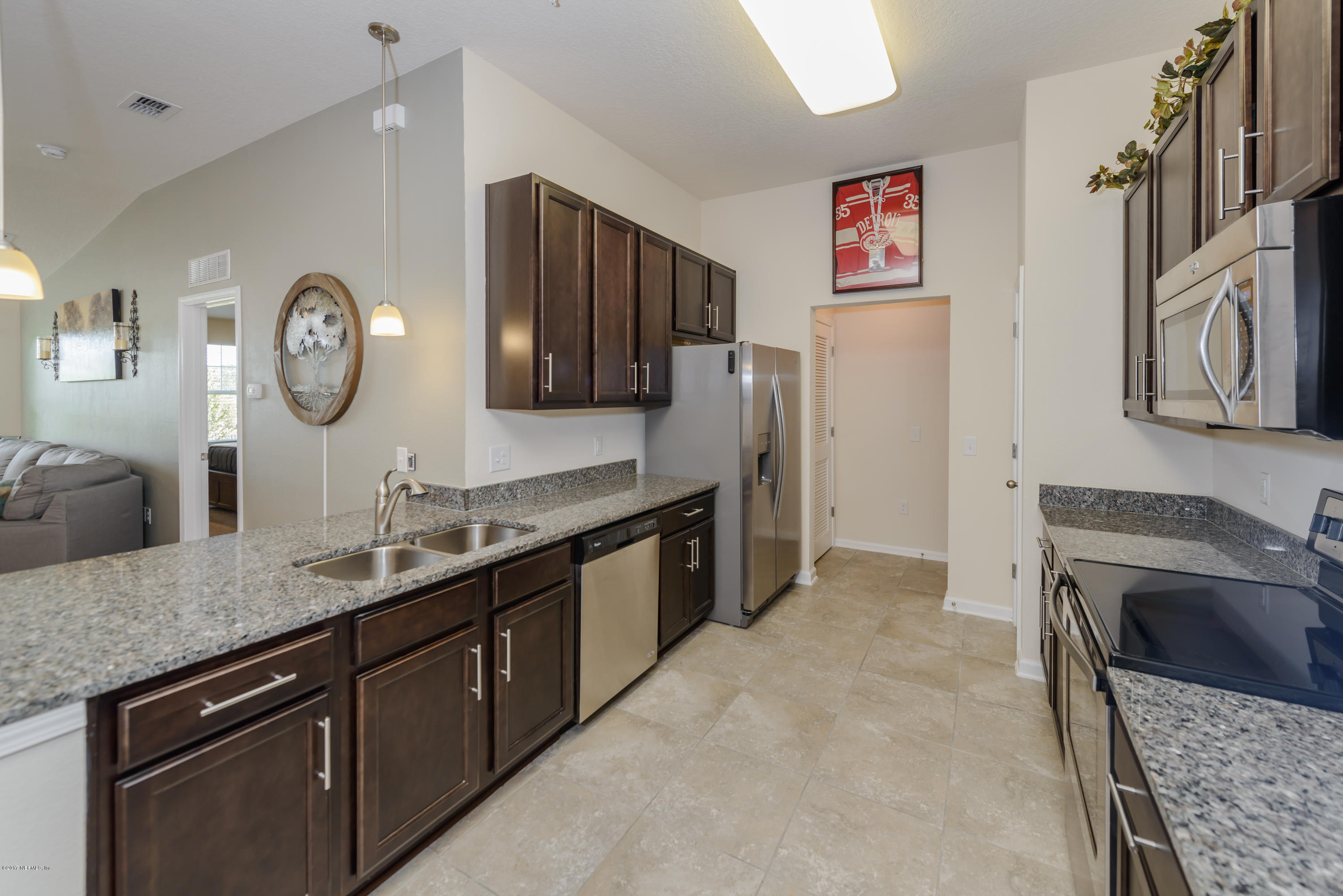 817 Golden Lake Loop St. Augustine, FL 32084 - Photo 11 of 30 a kitchen with stainless steel appliances granite countertop a sink stove and refrigerator