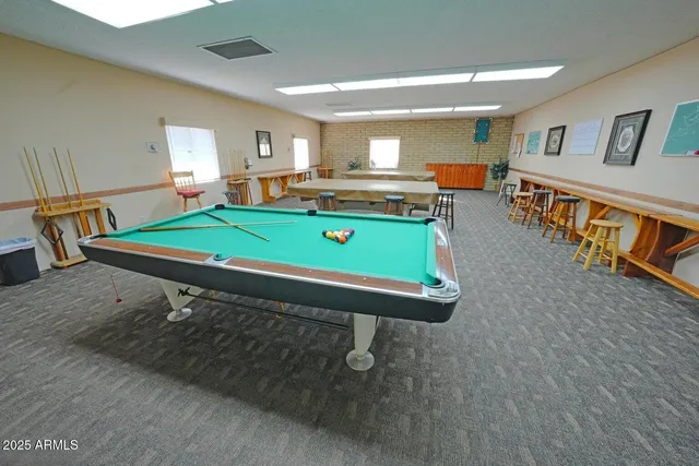 a room with pool table and windows