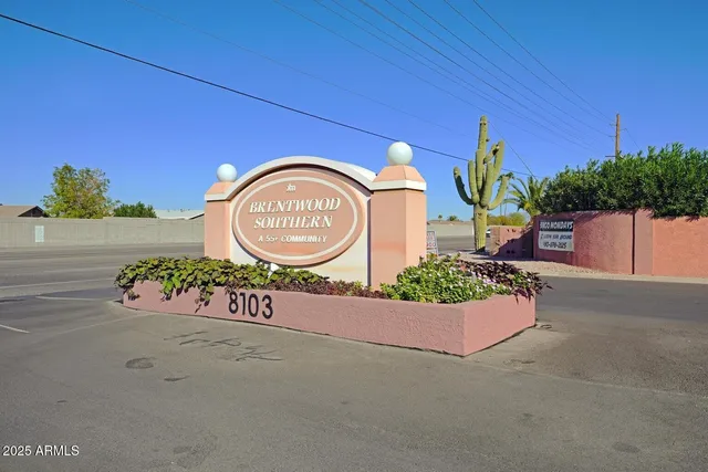 a street sign with potted plants in front of it