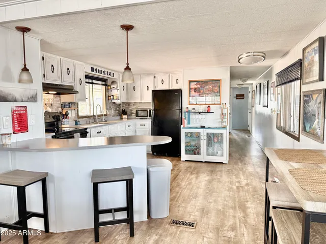a view of an empty room with wooden floor and windows