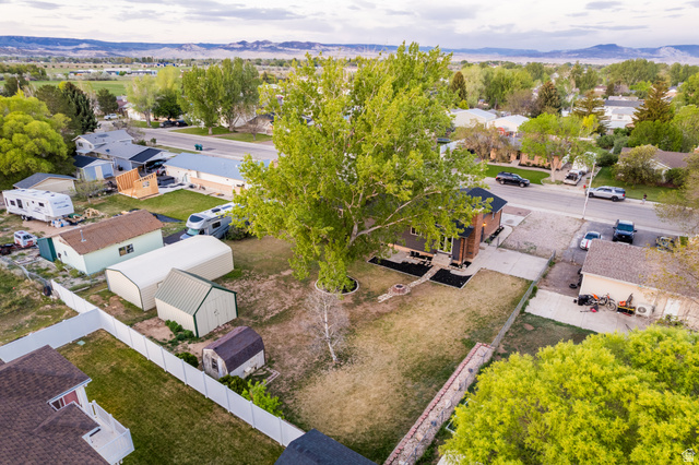 634 South 2100th Street West Vernal, UT 84078 - Photo 66 of 71 Expansive property featuring a large mature tree, a gravel driveway, and a fenced backyard