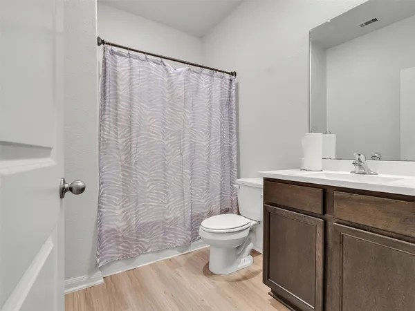 a bathroom with a sink a toilet a mirror and shower