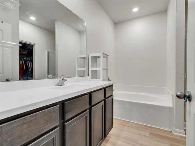 a bathroom with a sink a bathtub a mirror and a shower