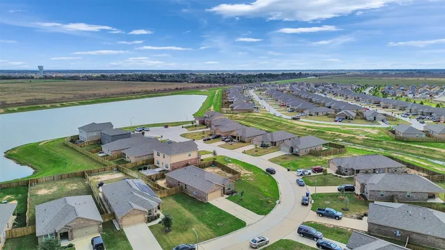 an aerial view of ocean and residential houses with outdoor space