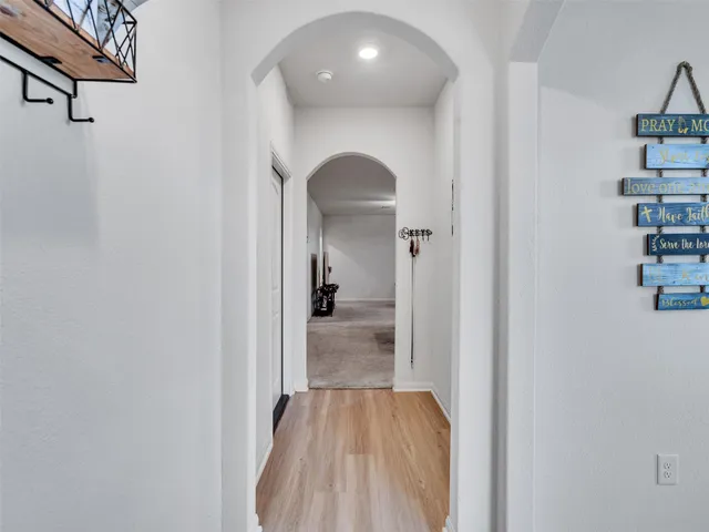 a view of a hallway with wooden floor and entryway