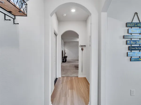 a view of a hallway with wooden floor and entryway