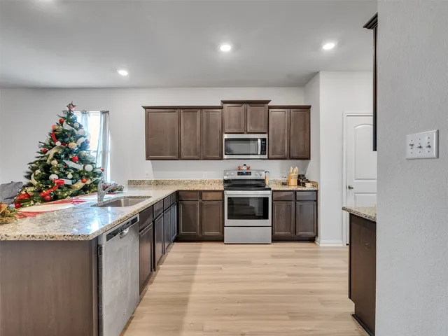a kitchen with kitchen island granite countertop a stove and a refrigerator