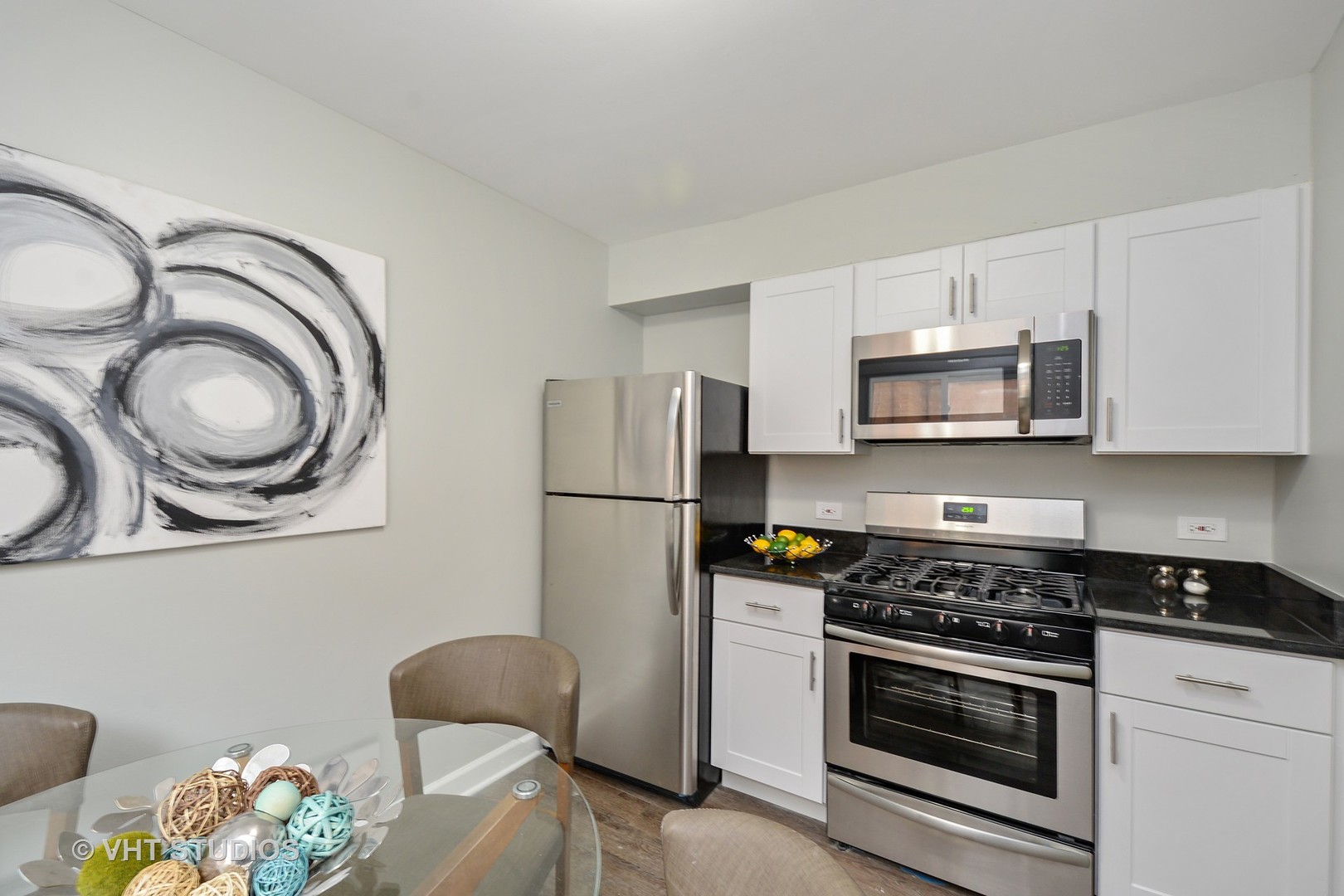 10077 Frontage Road, Unit E Skokie, IL 60077 - Photo 3 of 10 a kitchen with stainless steel appliances granite countertop a stove a refrigerator and a microwave