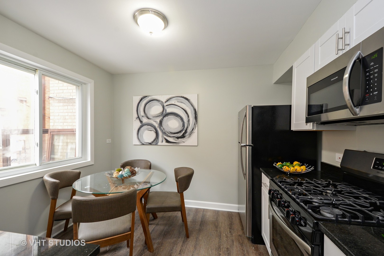10077 Frontage Road, Unit E Skokie, IL 60077 - Photo 4 of 10 a kitchen with stainless steel appliances granite countertop a stove top oven a sink dishwasher and cabinets with wooden floor