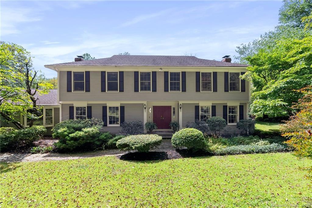 a front view of a house with yard and green space
