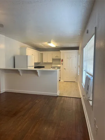 a view of a kitchen with wooden floor and electronic appliances