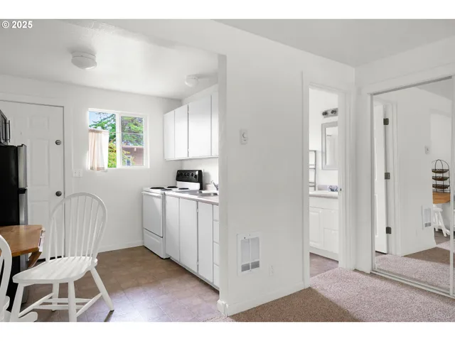 a view of kitchen with sink cabinets and window