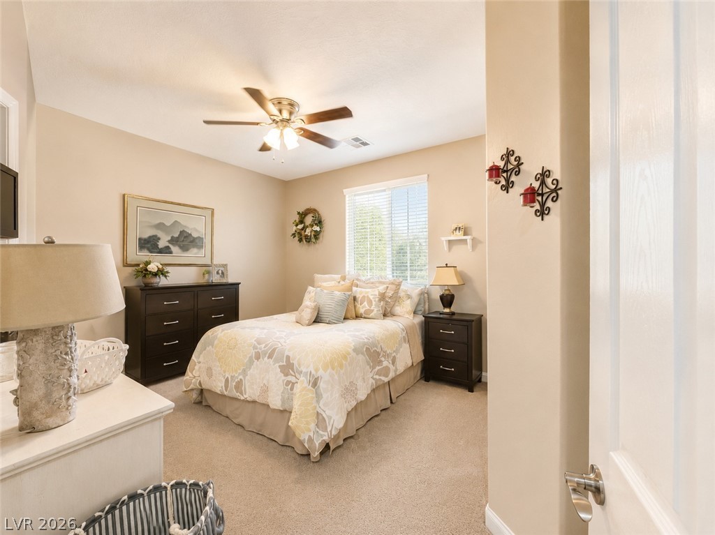 9724 University Ridge Avenue Las Vegas, NV 89149 - Photo 13 of 61 A comforting bedroom space features plush carpet and a window offering natural light.