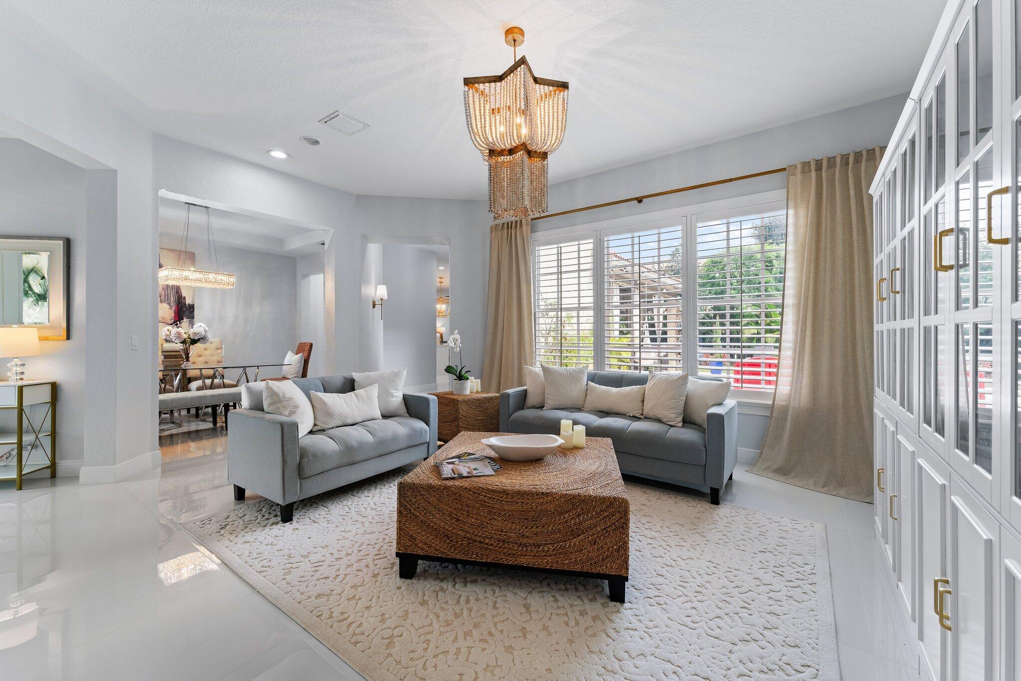 108 Via Azurra Jupiter, FL 33458 - Photo 12 of 78 a living room with furniture and a chandelier
