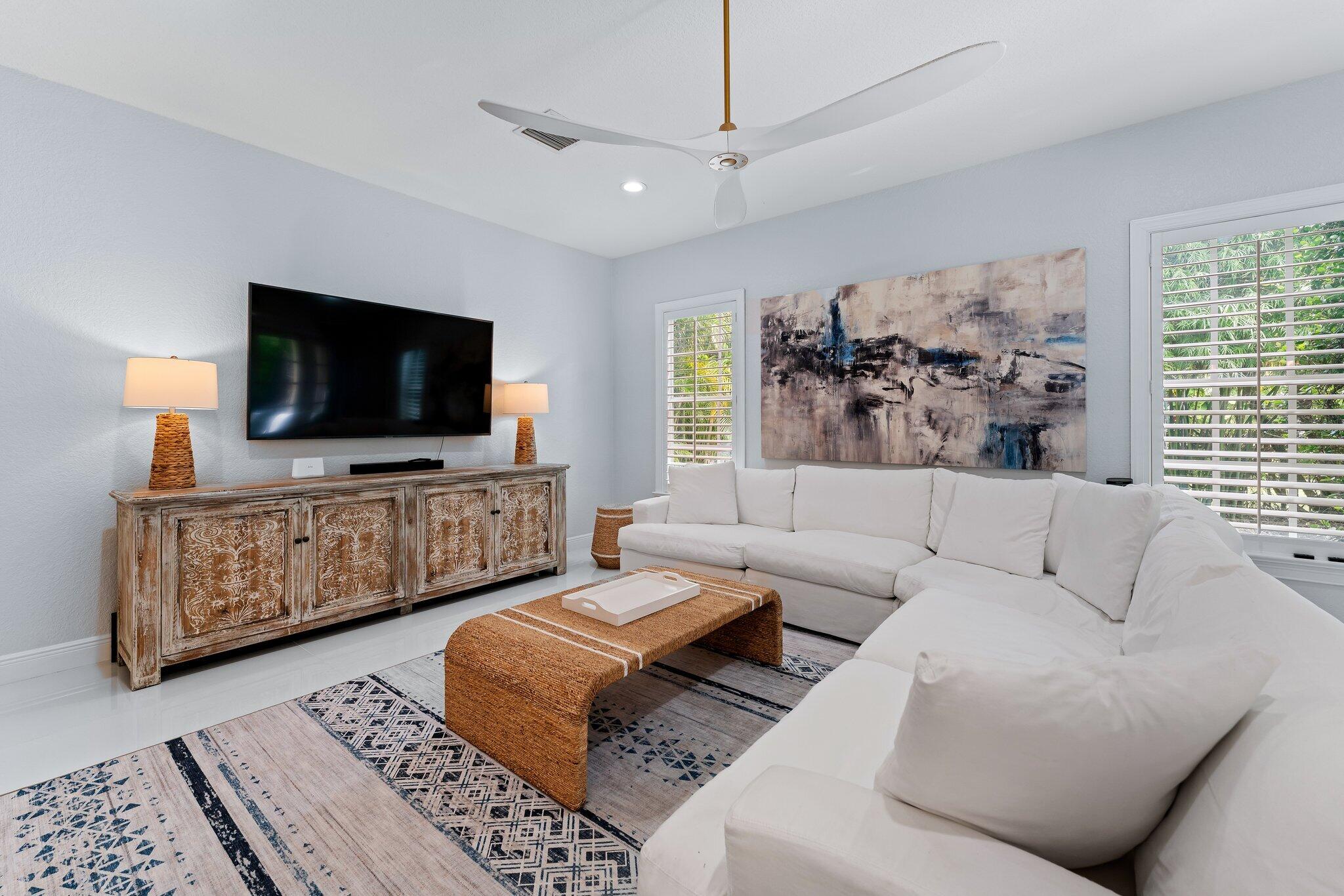 108 Via Azurra Jupiter, FL 33458 - Photo 28 of 78 a living room with furniture and a flat screen tv