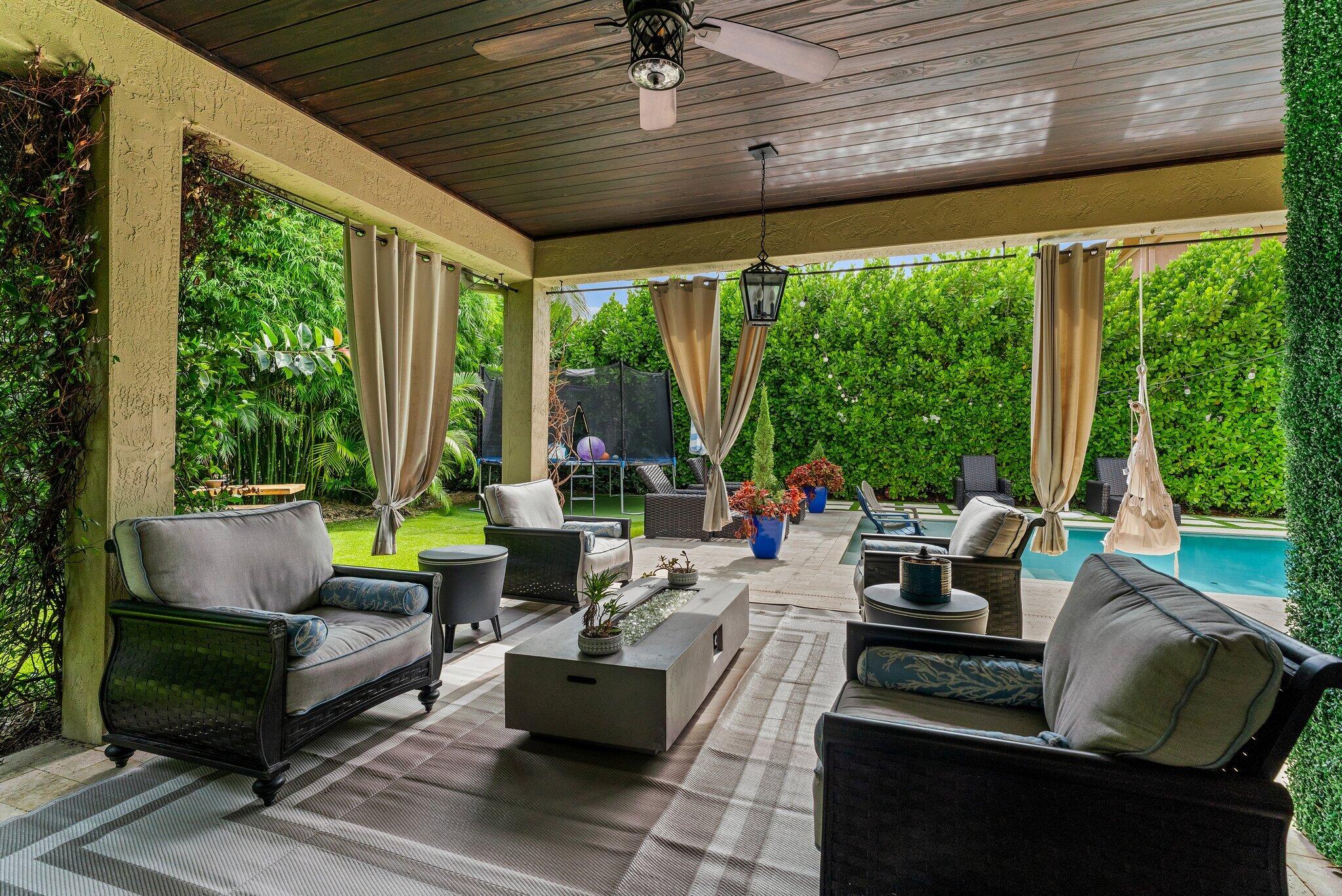 108 Via Azurra Jupiter, FL 33458 - Photo 32 of 78 a outdoor space with patio the couches and a dining table with garden view