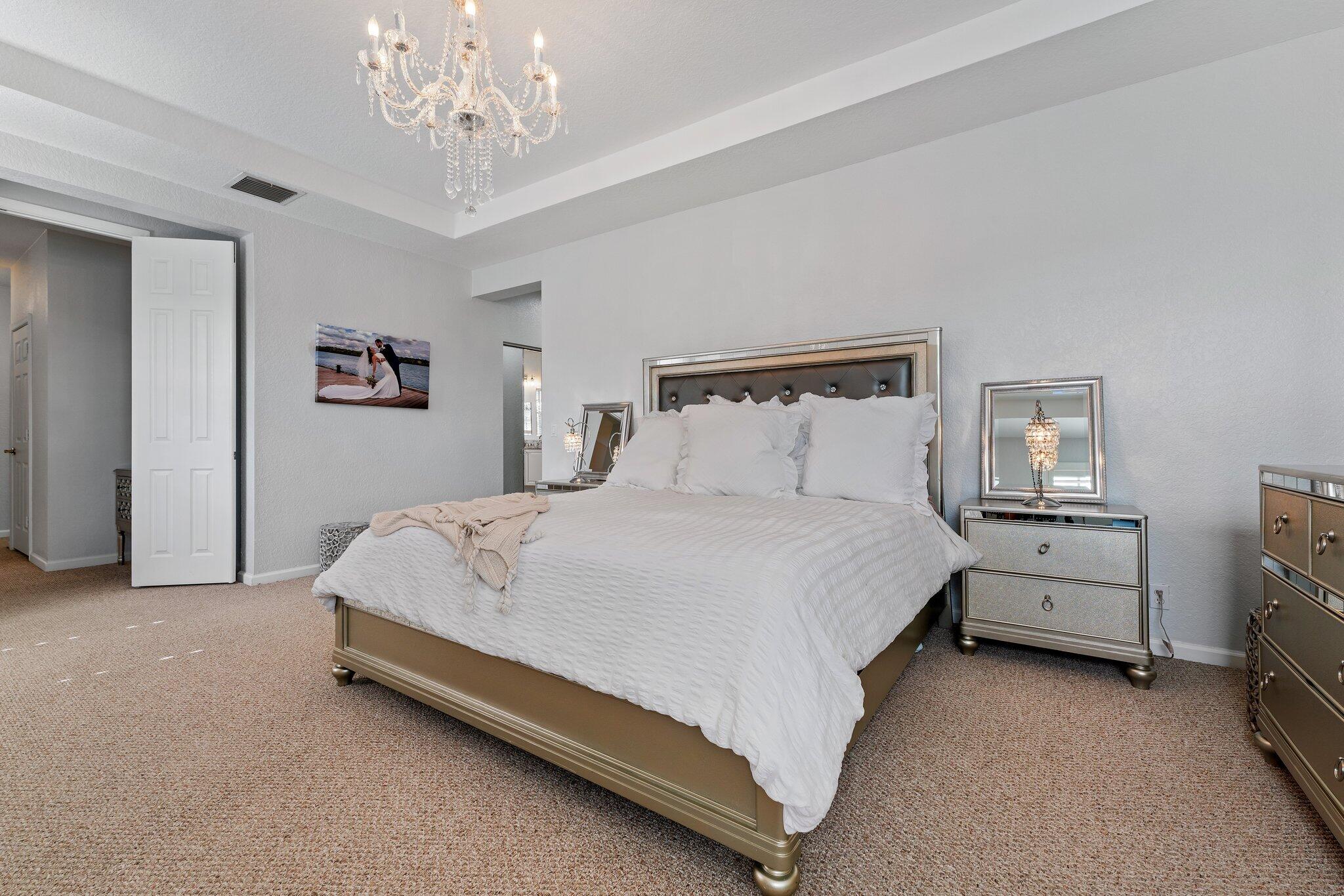 108 Via Azurra Jupiter, FL 33458 - Photo 47 of 78 a bed room with furniture and a chandelier