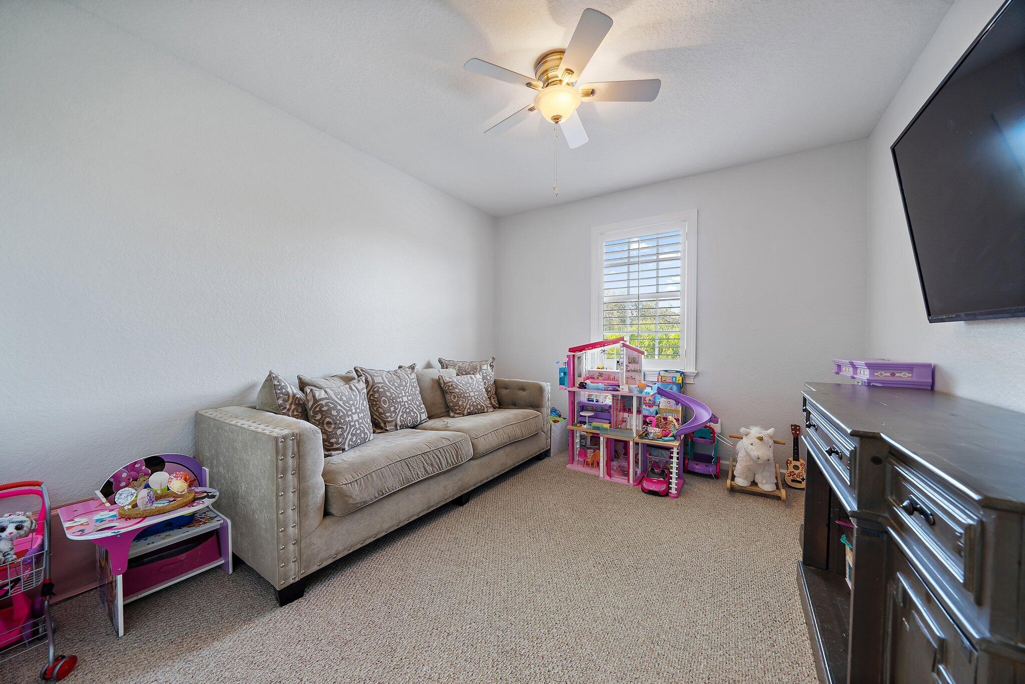 108 Via Azurra Jupiter, FL 33458 - Photo 56 of 78 a living room with furniture a flat screen tv and a chandelier