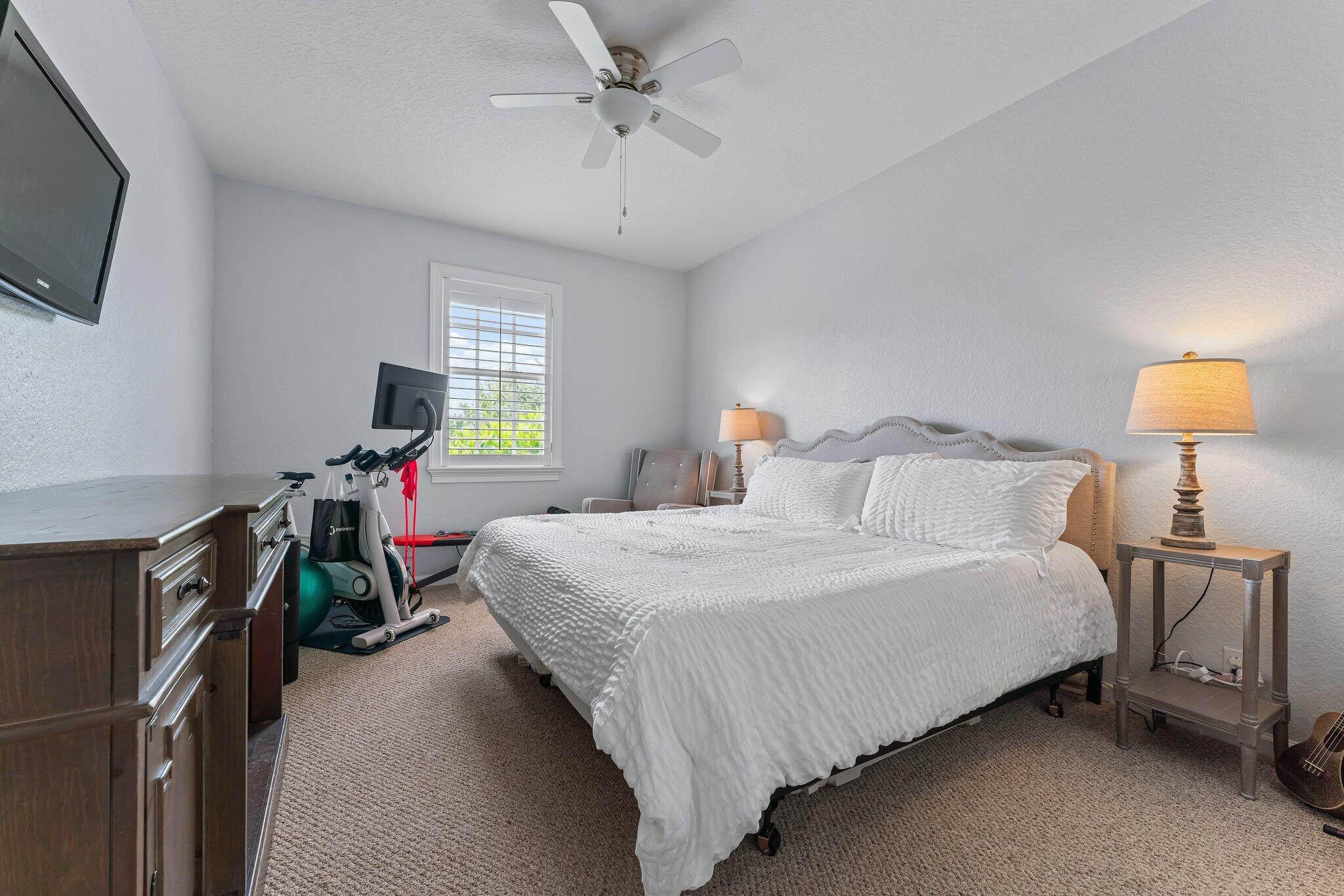 108 Via Azurra Jupiter, FL 33458 - Photo 58 of 78 a bedroom with a bed flat screen tv and a window