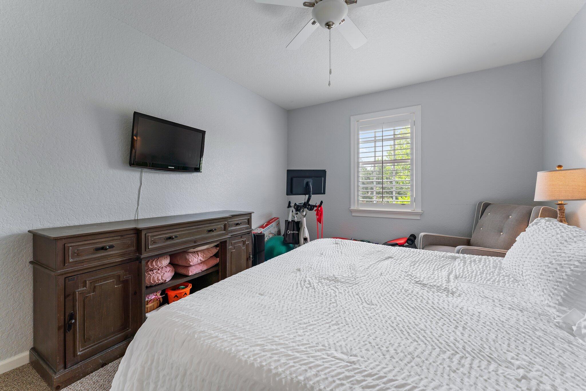 108 Via Azurra Jupiter, FL 33458 - Photo 59 of 78 a bedroom with a bed and a flat screen tv