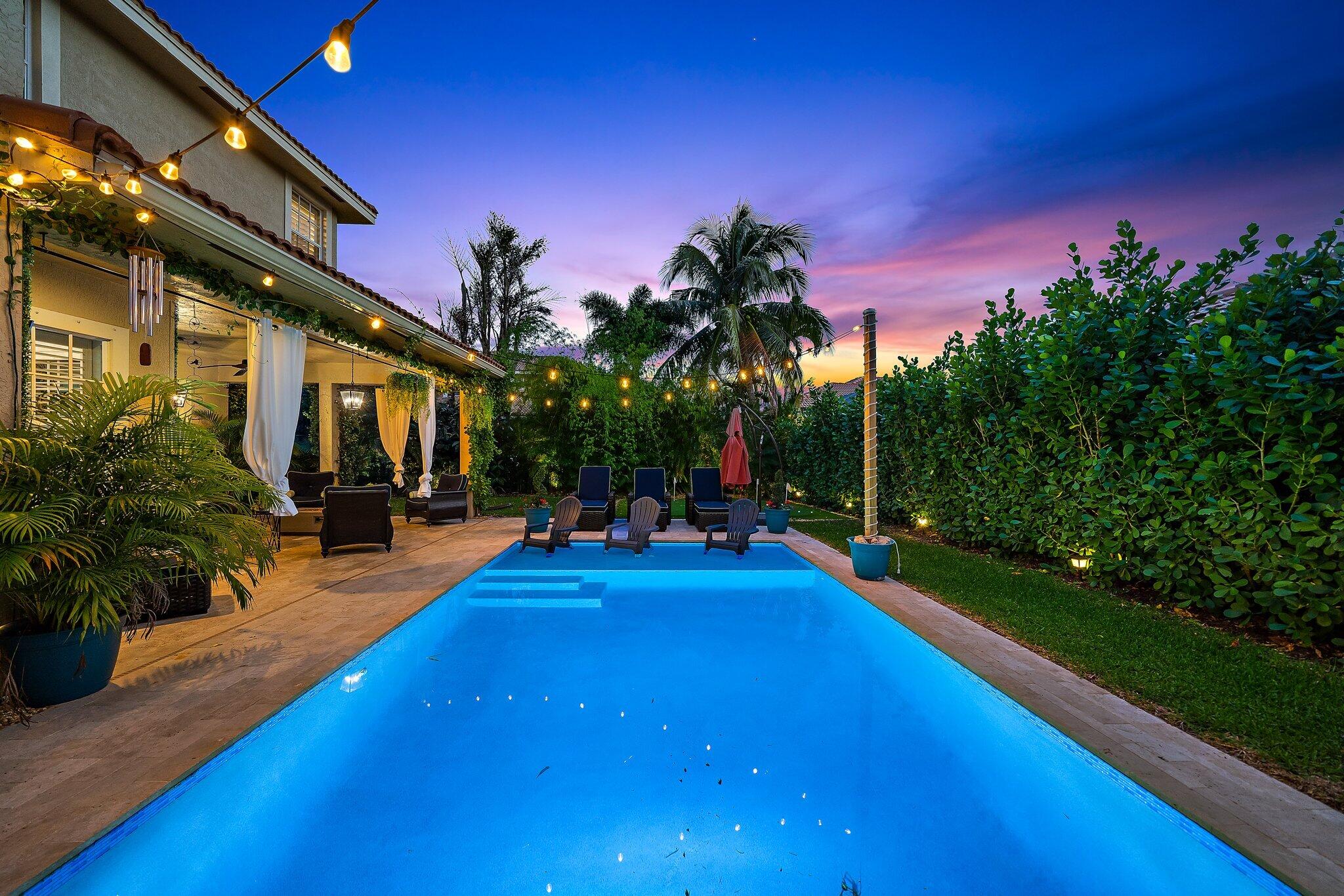 108 Via Azurra Jupiter, FL 33458 - Photo 66 of 78 a view of a swimming pool with an outdoor seating and a yard