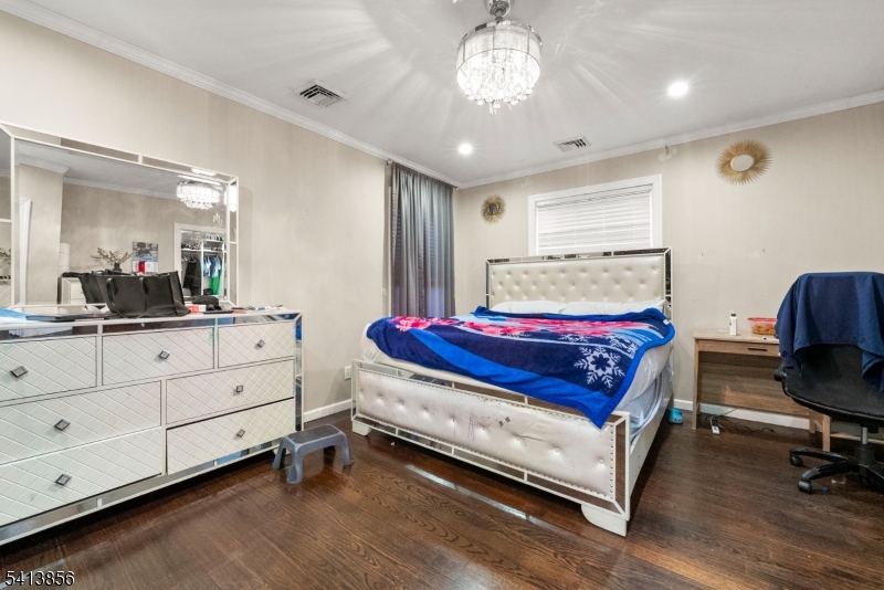 263 Stiles Street Elizabeth, NJ 07208 - Photo 21 of 30 a spacious bedroom with a bed and a chandelier