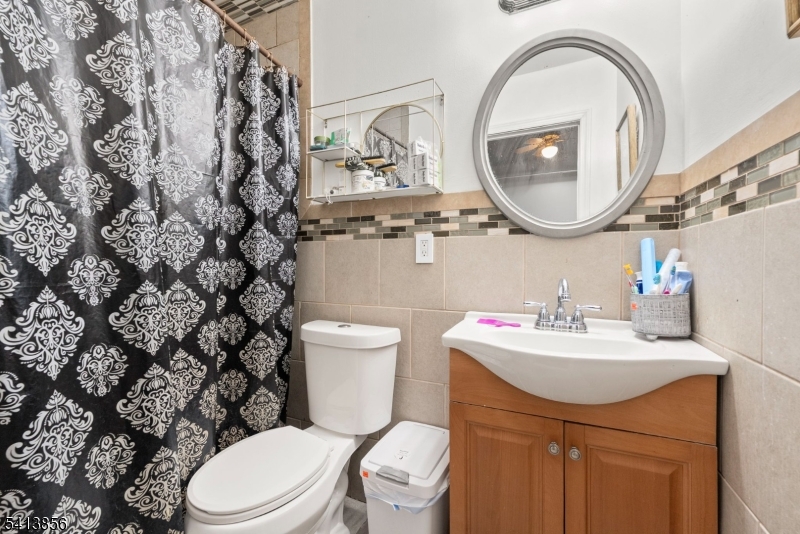 263 Stiles Street Elizabeth, NJ 07208 - Photo 22 of 30 a bathroom with a toilet sink vanity and mirror