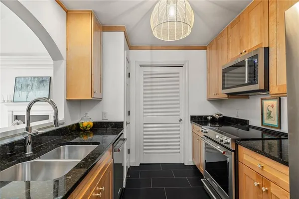 a kitchen with stainless steel appliances a stove sink microwave and cabinets