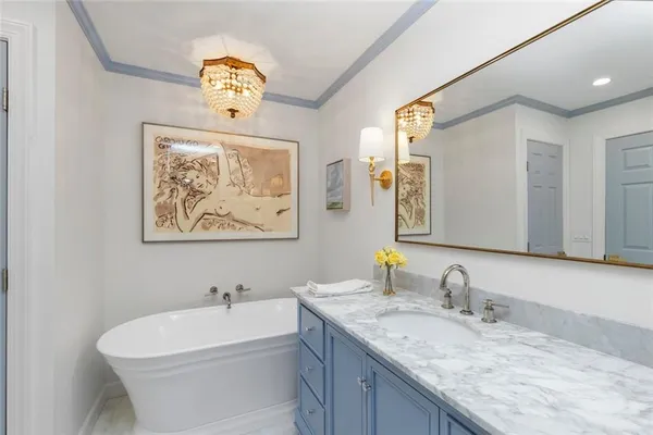 a bathroom with a granite countertop sink a mirror and a bathtub