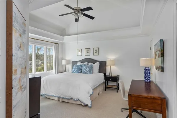 a bedroom with a large bed and a chandelier