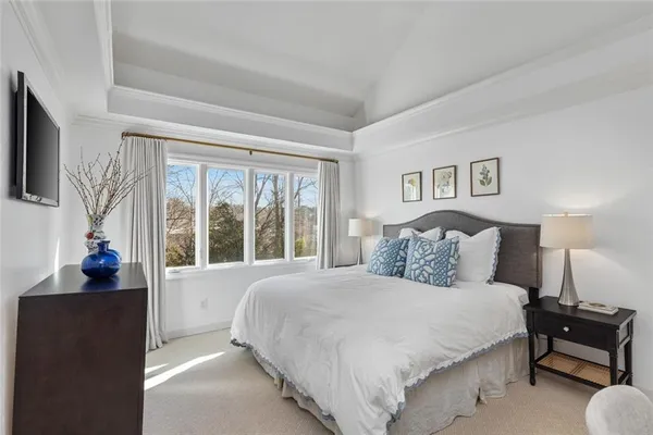 a large bedroom with a bed and a flat tv screen