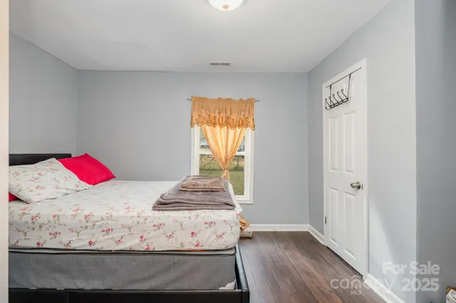 a view of a bedroom with wooden floor