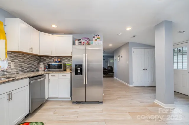 a kitchen with stainless steel appliances a refrigerator sink and microwave