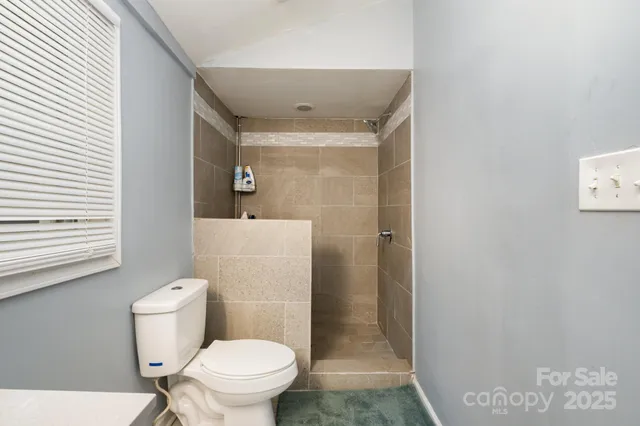 a bathroom with a toilet and a shower