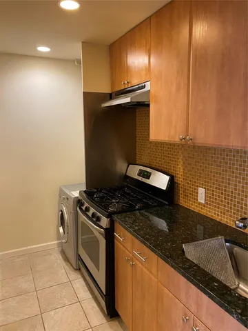 a kitchen with granite countertop a stove and a sink