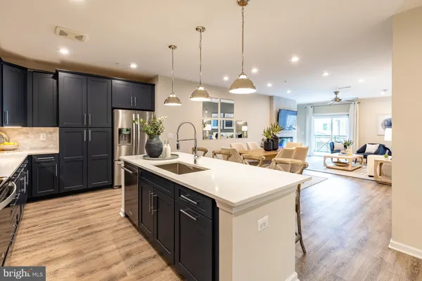 a kitchen with kitchen island a sink appliances and a counter top space