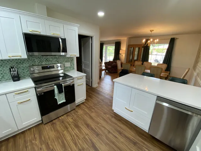 a kitchen with stainless steel appliances a stove microwave and sink