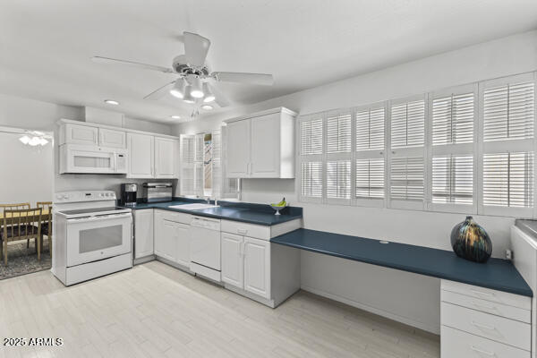 a kitchen with granite countertop a stove a sink and white cabinets