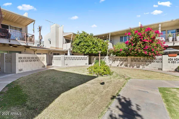 a kitchen with granite countertop a refrigerator a sink and white cabinets