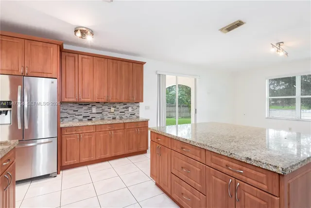 a kitchen with stainless steel appliances granite countertop a refrigerator and a sink