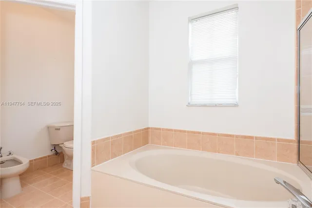 a white bath tub sitting next to a toilet